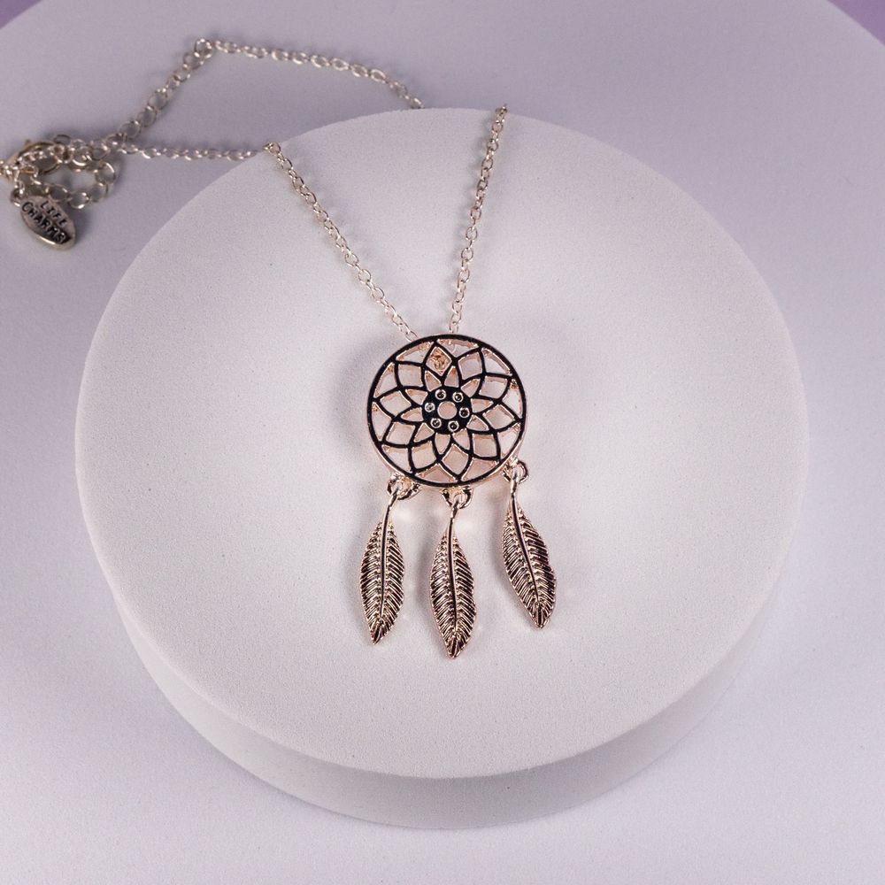 Silver dreamcatcher necklace with feather charms on white display.