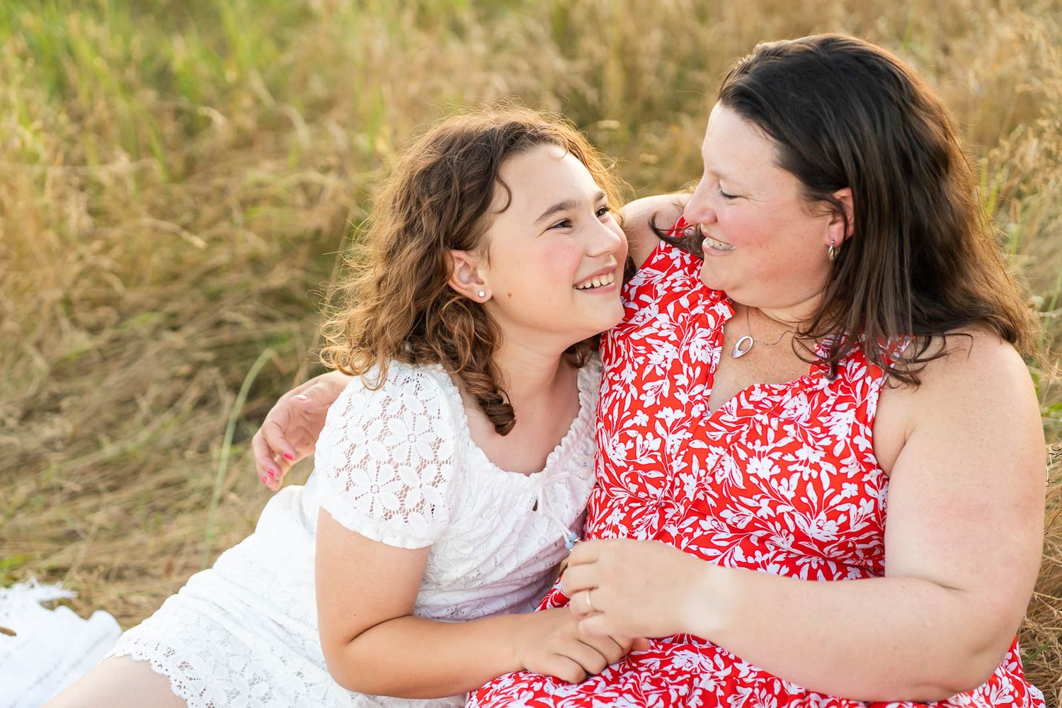 Mother daughter candidly smile in a field in Redmond