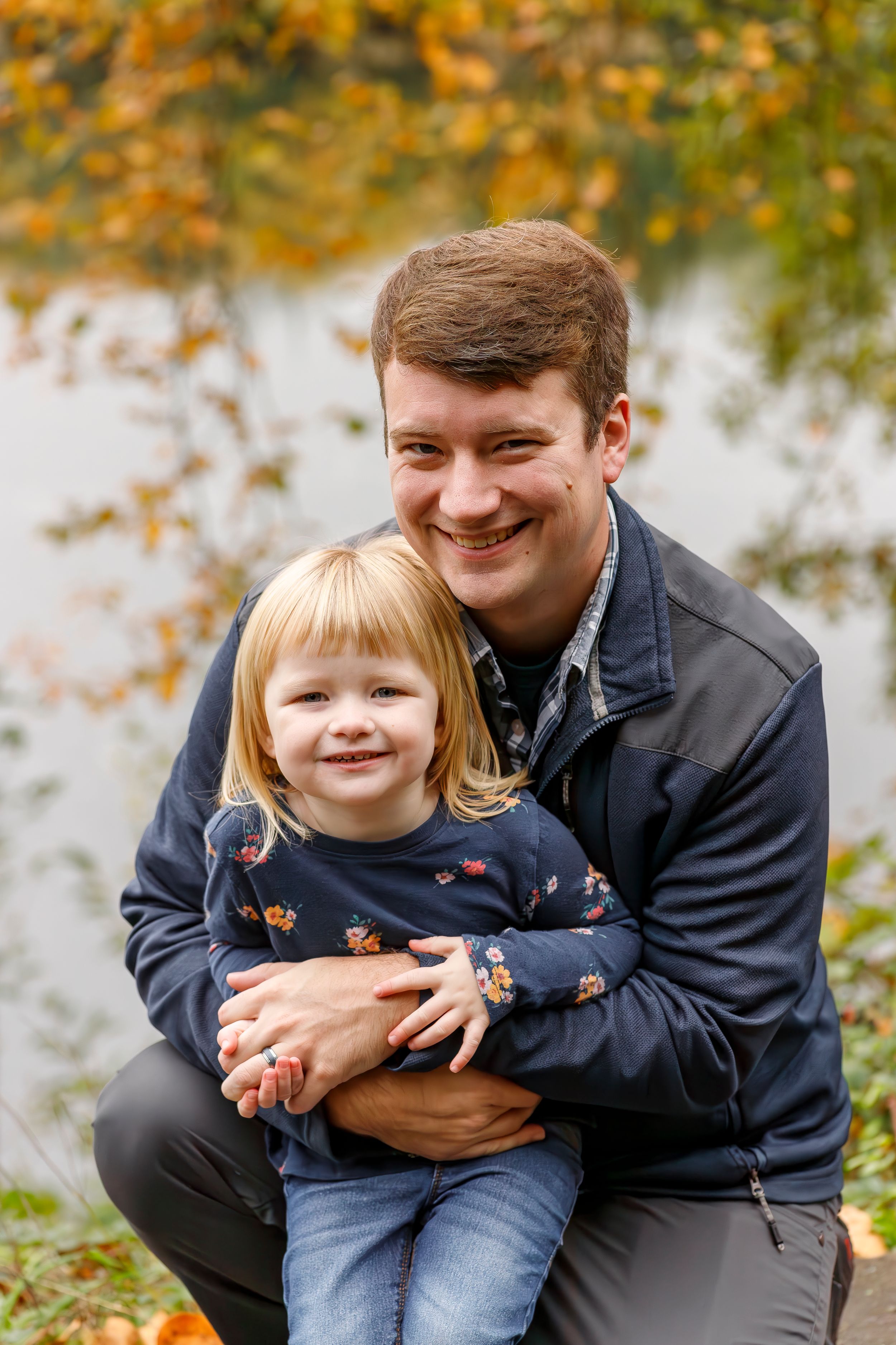 Parent and child share joyful moment together outdoors during fall season.