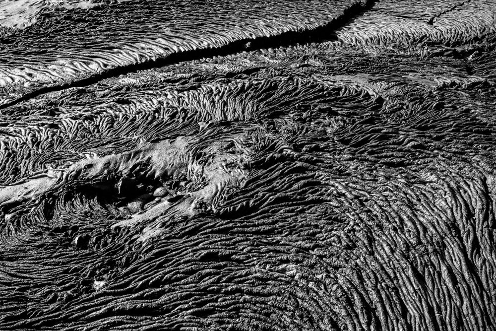 Detailed black and white view of volcanic rock formations showing intricate flow patterns.