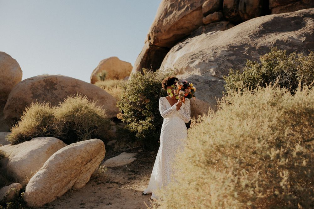 Wedding photo session in a desert setting with large boulders and Joshua trees.