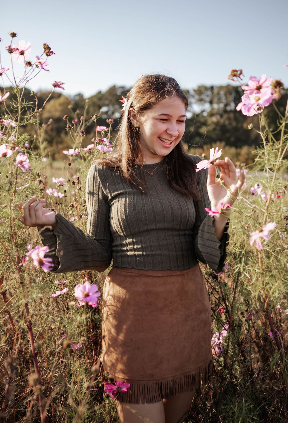 A joyful moment captured in a wildflower field with pink cosmos flowers on a sunny day.