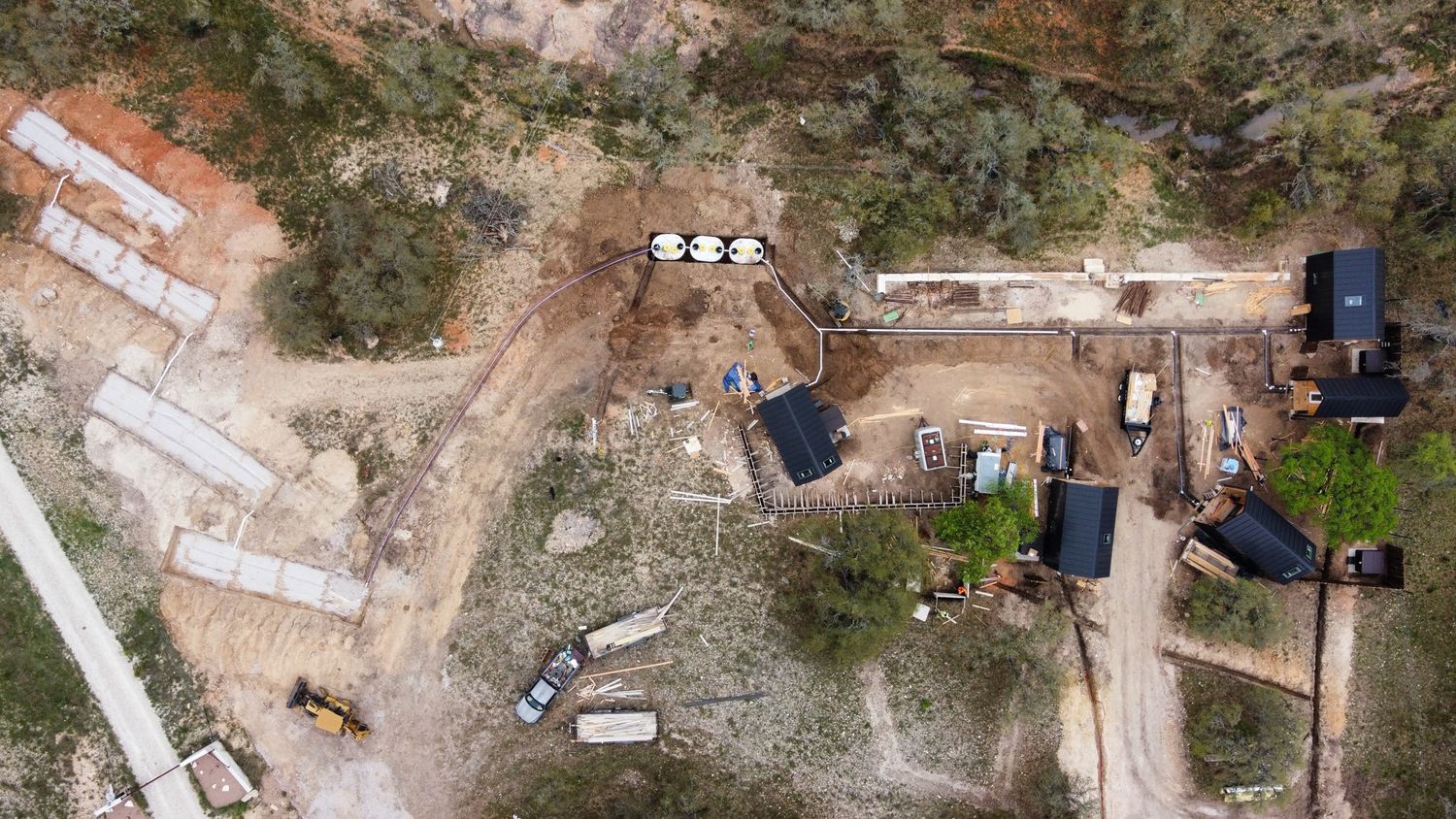 Aerial view of a construction site with vehicles and equipment in a quarry or excavation area.