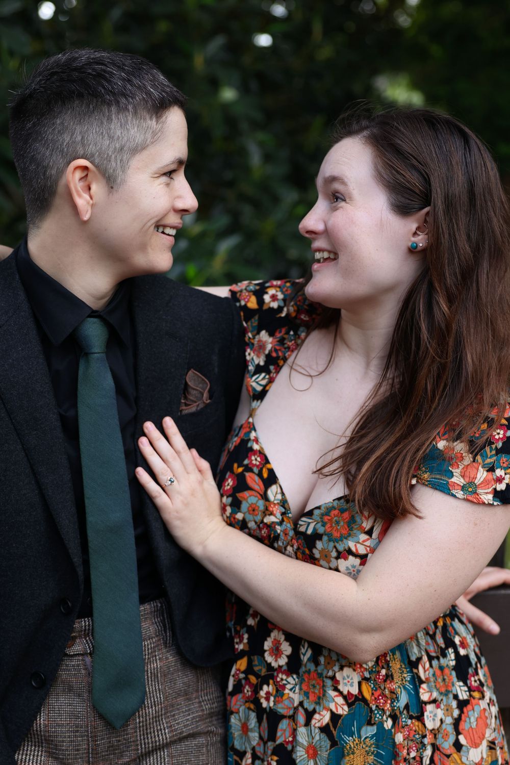 Couple in formal attire sharing a romantic moment outdoors.