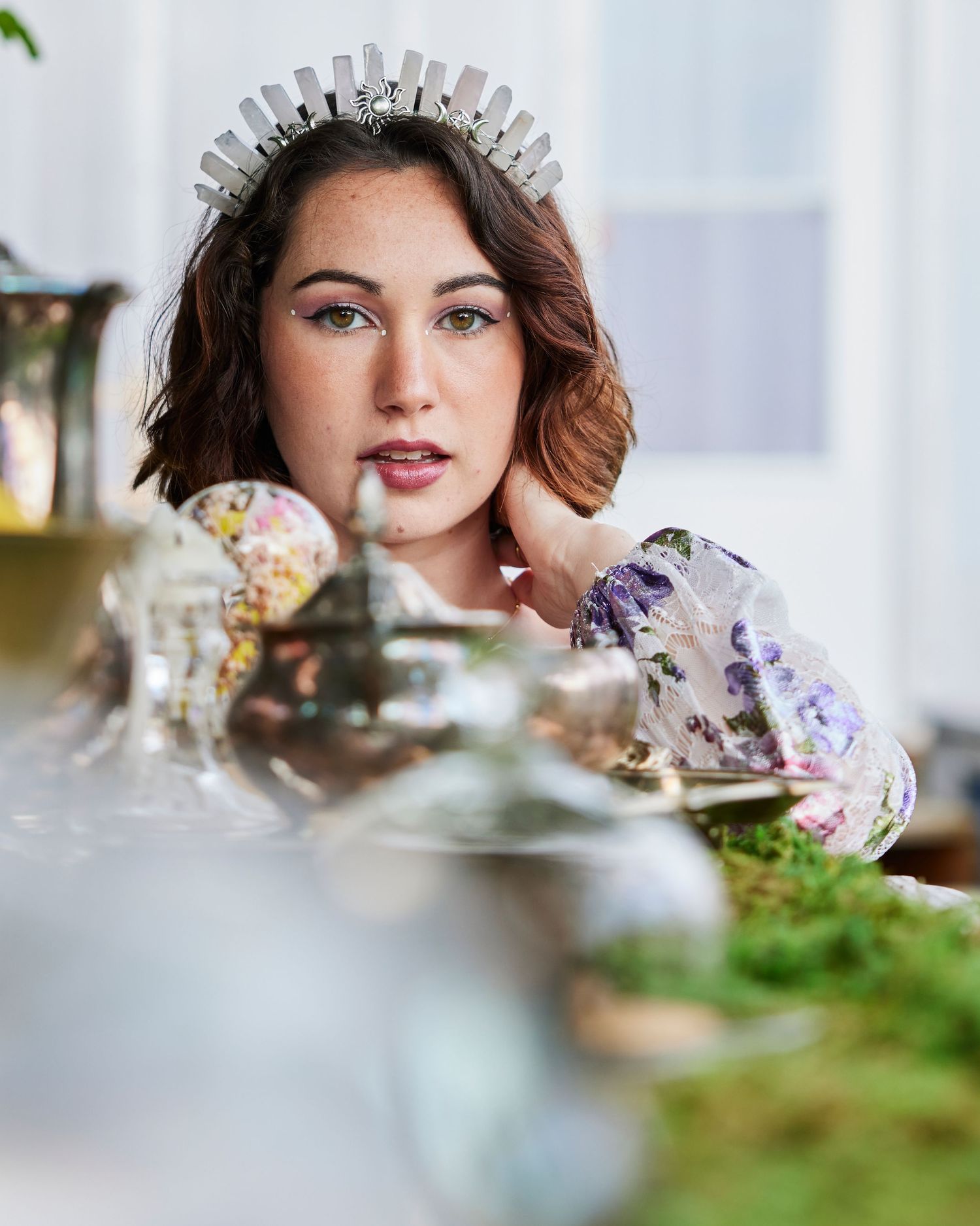 Ethereal portrait with crystal crown and delicate table setting with crystals and flowers.