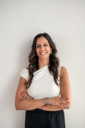 Professional headshot series showing confident poses against white background wearing black and white outfit.