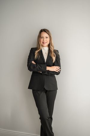 Professional business portrait series showing confident poses in black suit against light gray background.