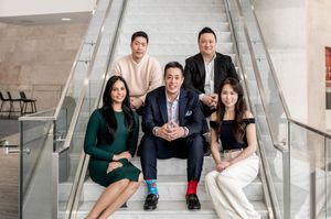 A group poses together on modern stairs in formal attire during a photo session.