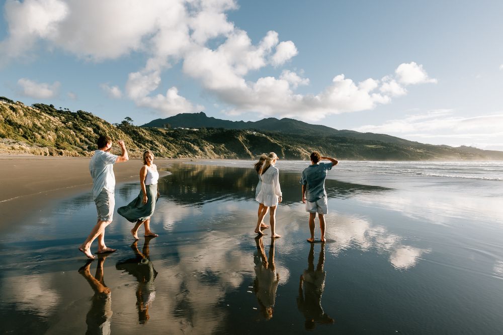 family photo walking in water on the beach