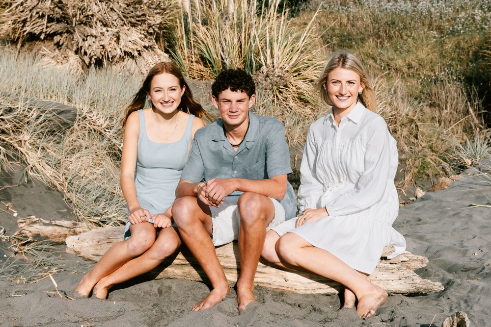 Siblings photo at a beach on a log