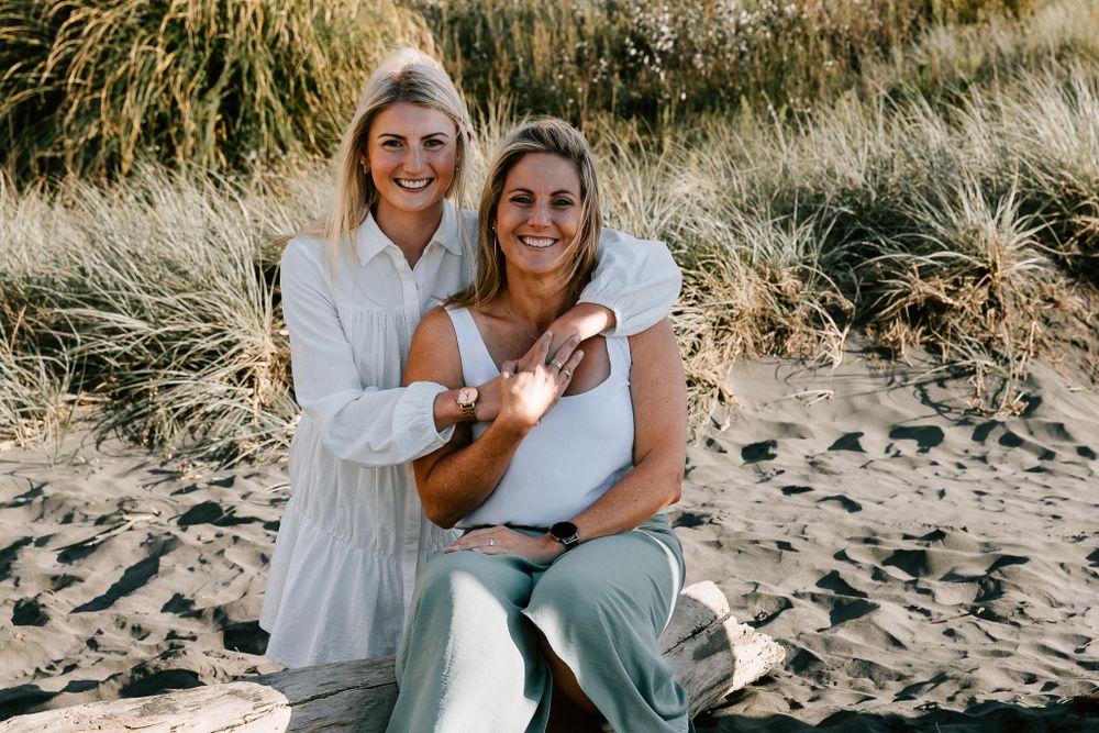 mum and daughter photo at a beach on a log