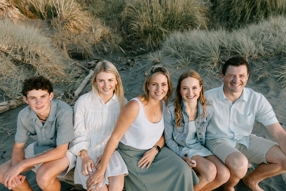 Family photo on a log at the beach