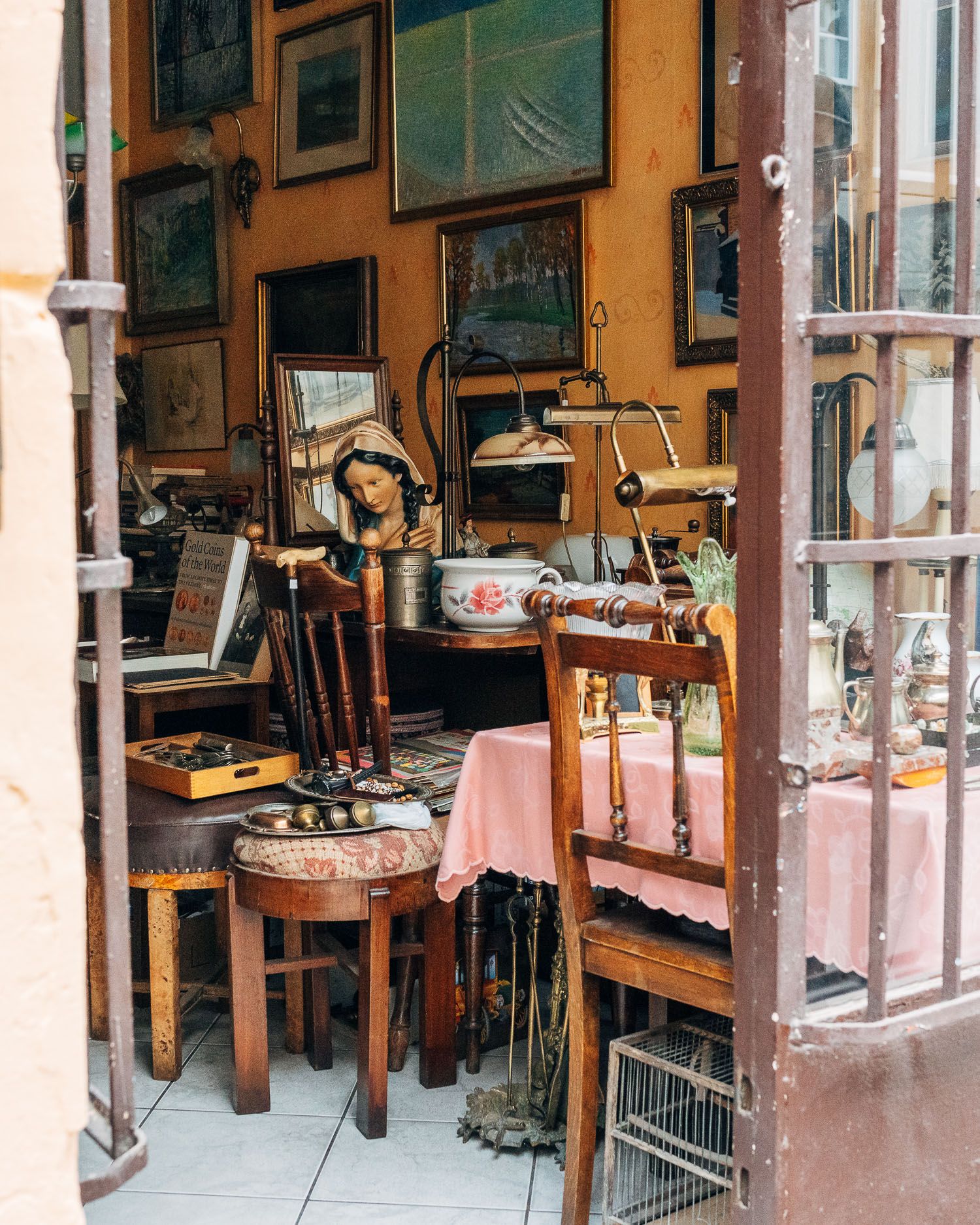 Vintage antique shop interior with wooden furniture and decorative items displayed.