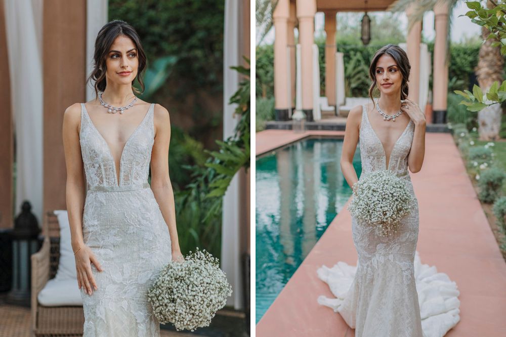 A stunning bridal portrait featuring a plunging V-neck lace wedding gown and baby's breath bouquet by a pool.
