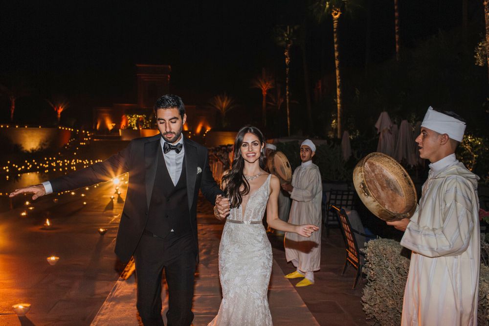 Moroccan-style wedding celebration at night with traditional musicians and glowing lanterns.