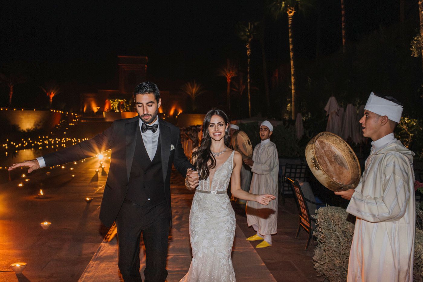 Moroccan-style wedding celebration at night with traditional musicians and glowing lanterns.