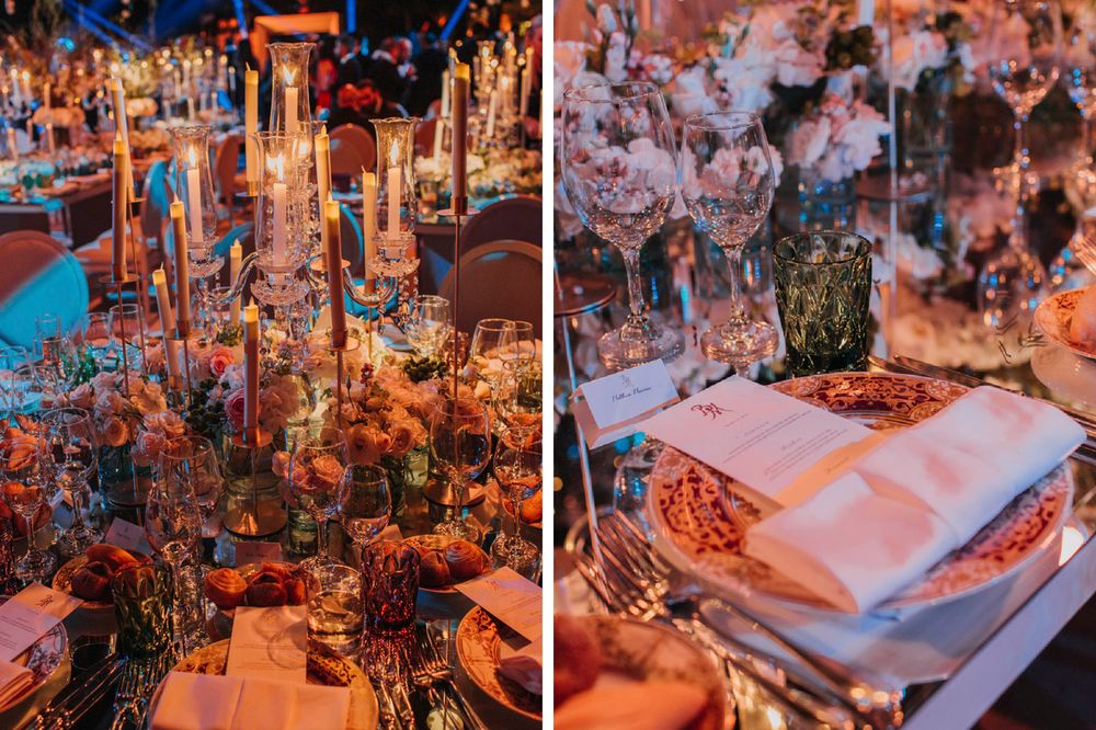 Elegant wedding reception table settings with tall candles and floral arrangements in warm, romantic lighting.