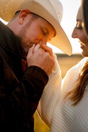 portrait of cinematic couple in field at golden hour in love