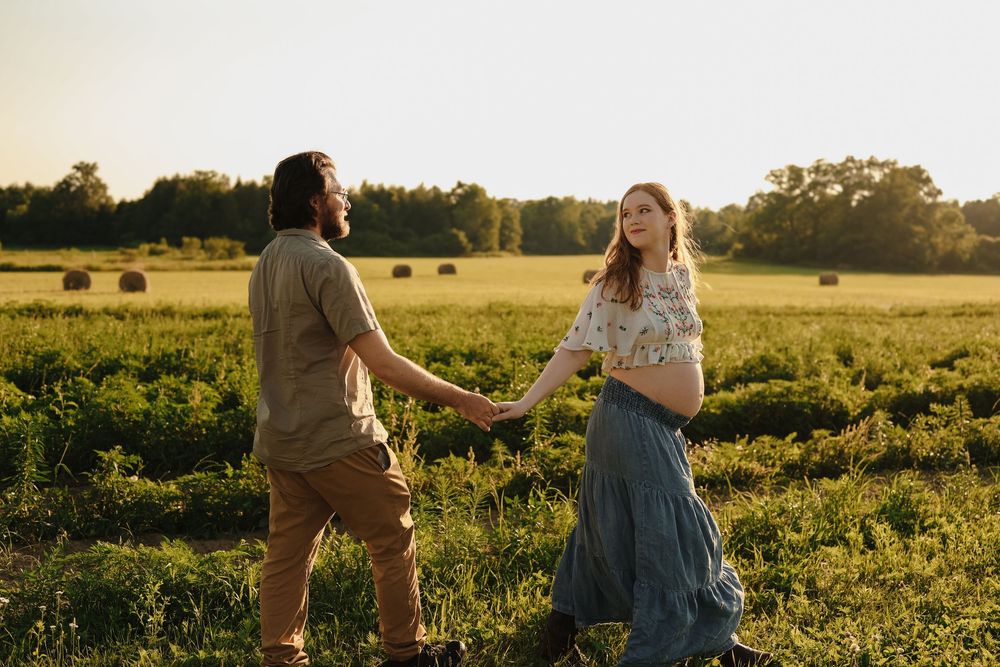A couple shares a romantic moment during golden hour in a blooming countryside meadow surrounded by wildflowers.
