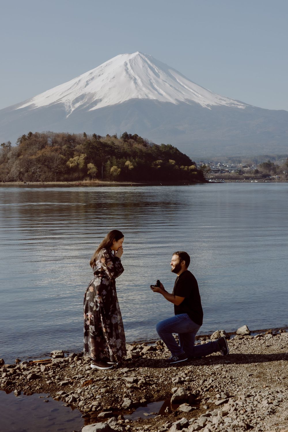 A marriage proposal takes place on the shores of Lake Kawaguchiko with snow-capped Mount Fuji in the background.