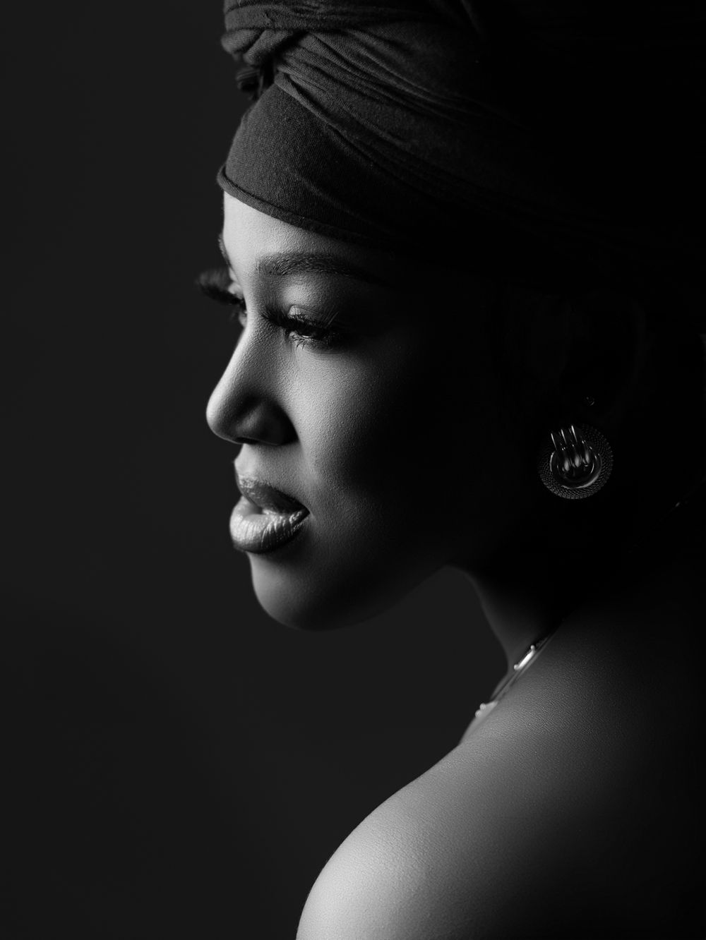 Dramatic black and white profile portrait with moody lighting and shadows creating an artistic silhouette effect in Atlanta photo studio.