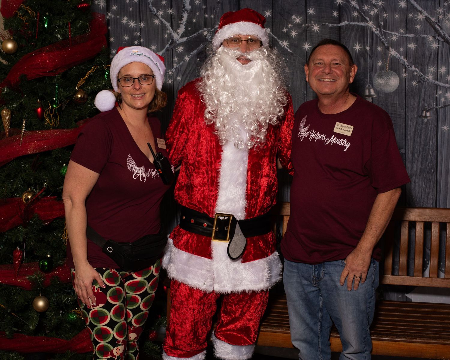 A holiday portrait setup with Santa Claus and Christmas decorations against a grey backdrop.