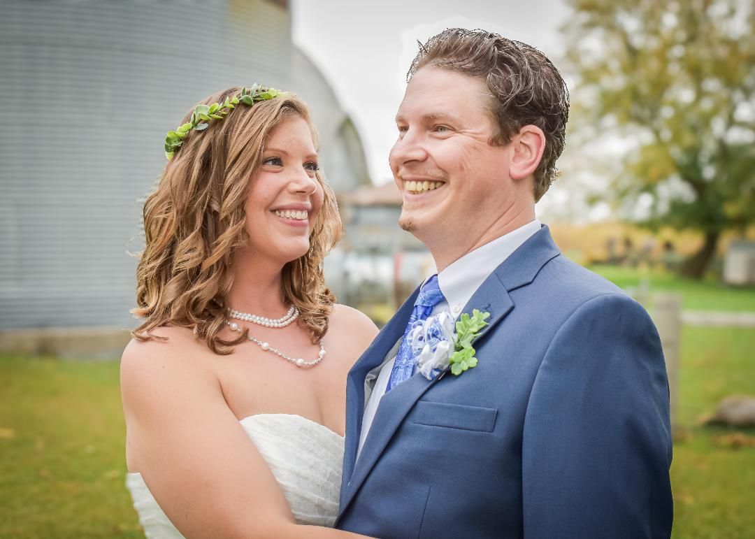 Intimate Wedding photo of a laughing bride and groom on a farm.  Blue Onion Photography.