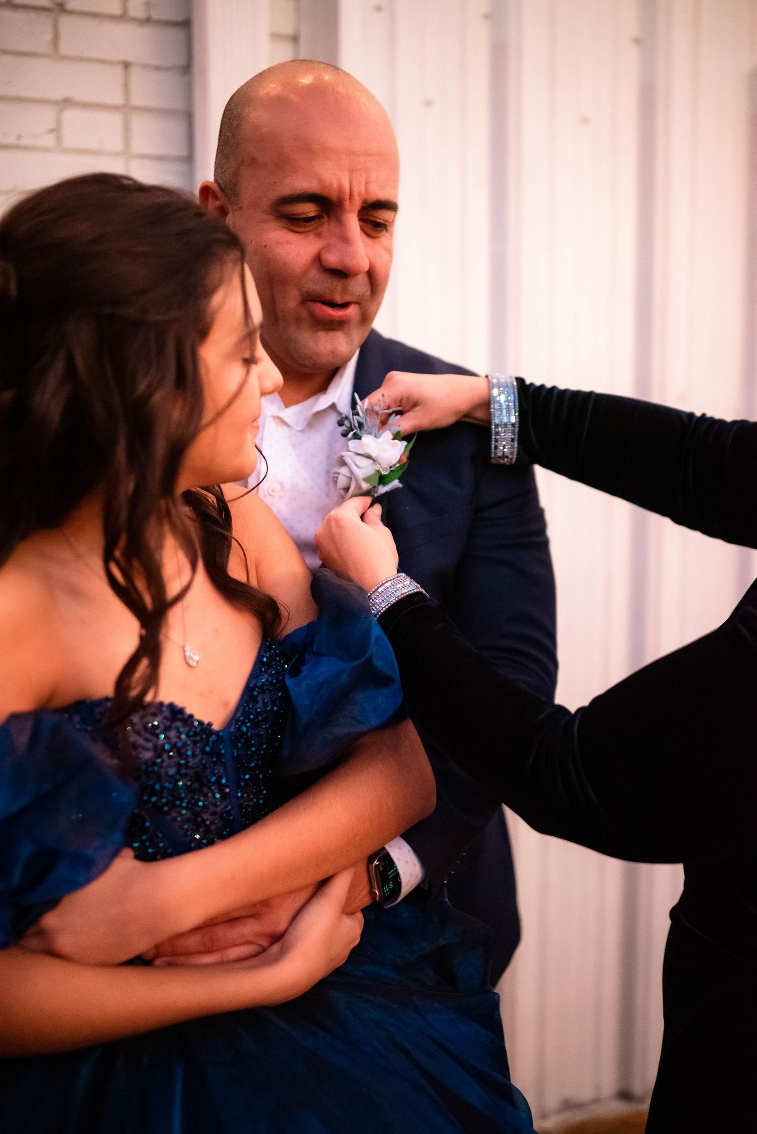 Sweet candid moments between a dancing couple in formal attire against white backdrop.