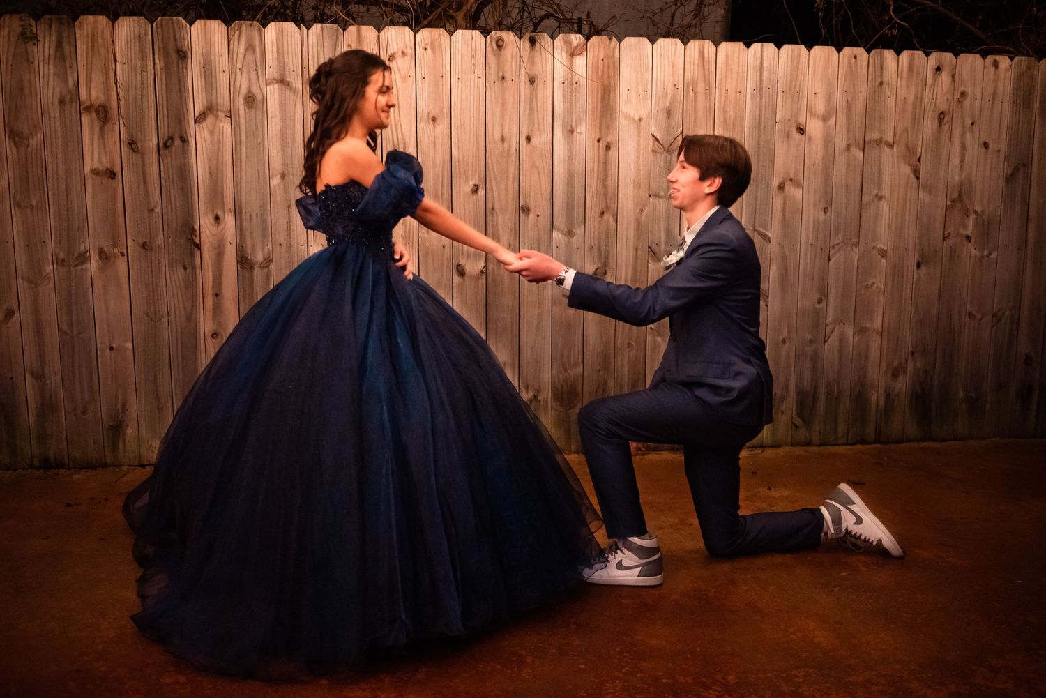 Series of dance poses and movements in formal wear against wooden fence.