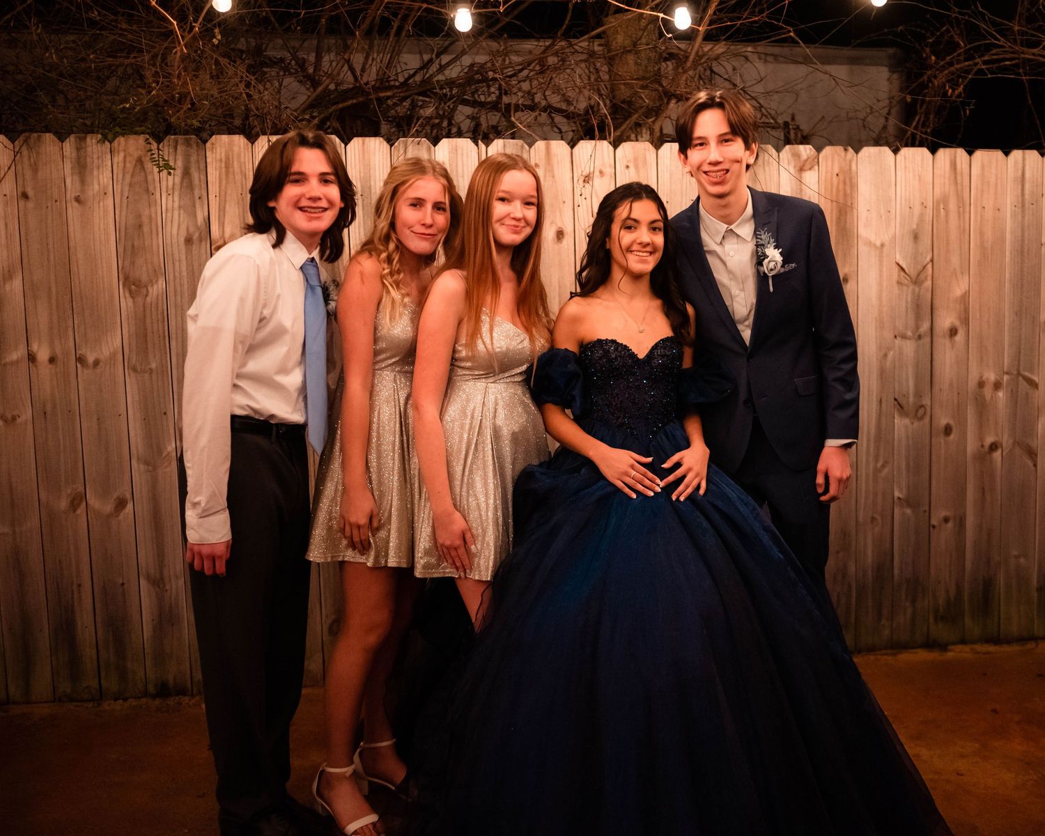 Group photo session in formal attire against rustic wooden background.