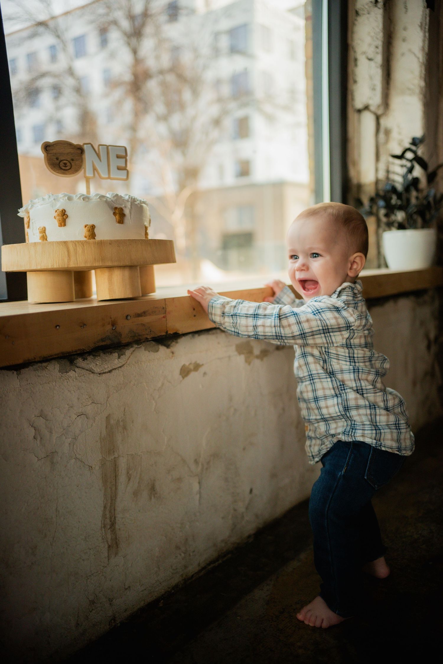 Baby in plaid shirt exploring near a rustic window ledge in sequence of candid shots.