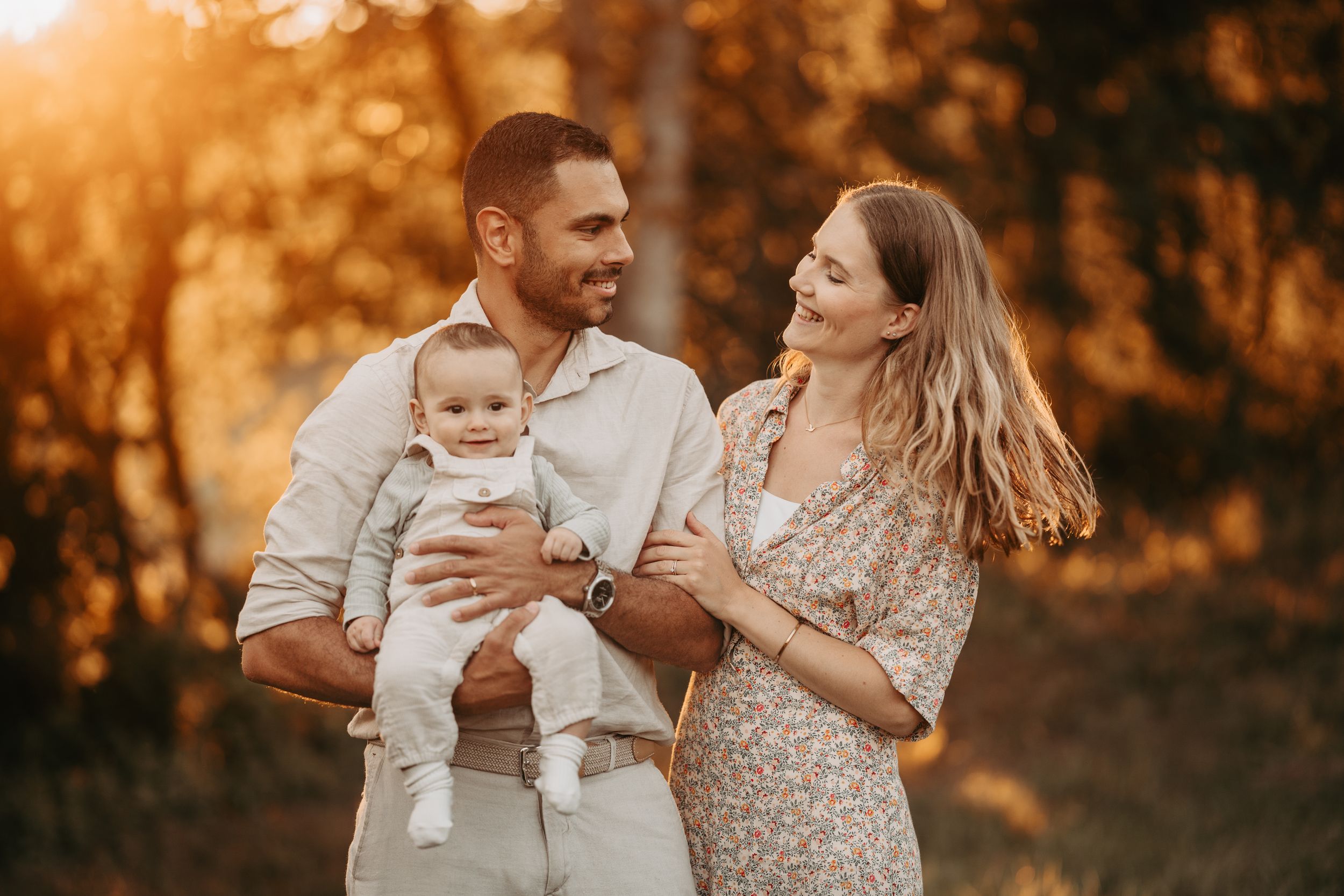 Happy family moment captured during sunset in natural outdoor setting.