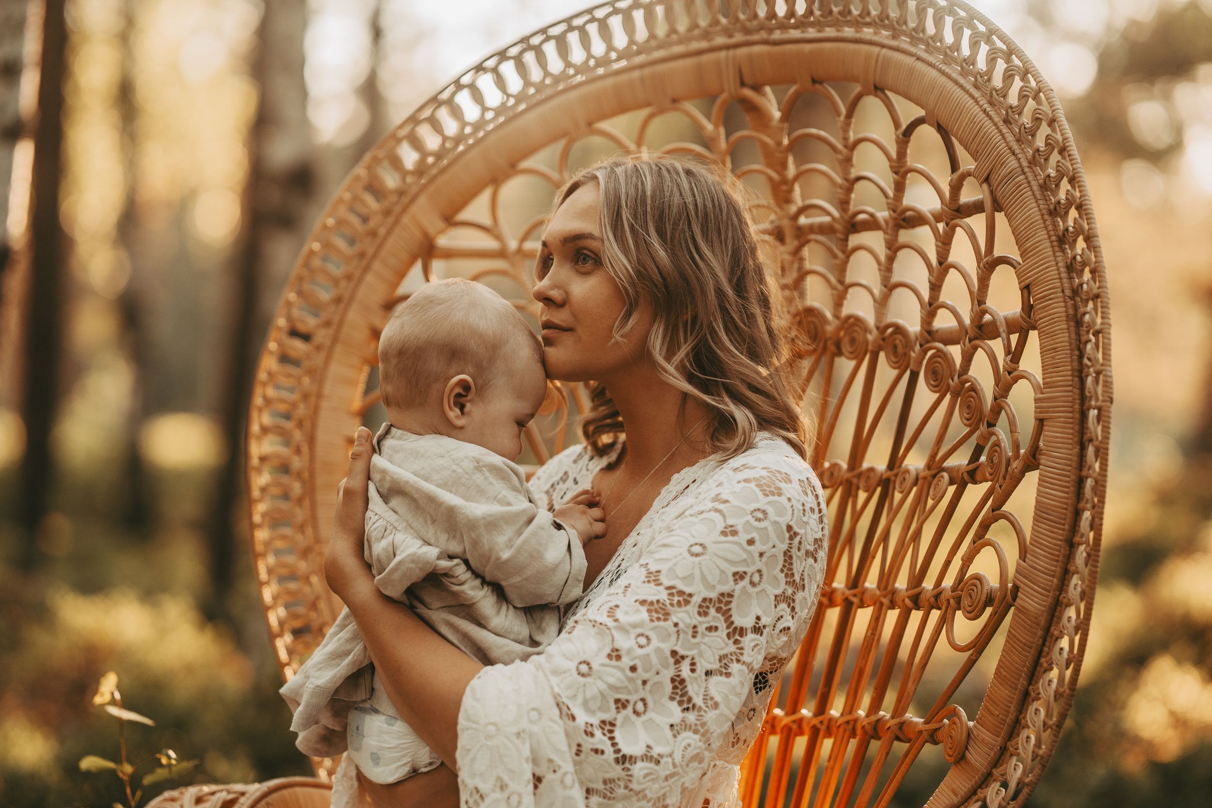 Bohemian scene with peacock chair featuring tender moment in dappled forest light.