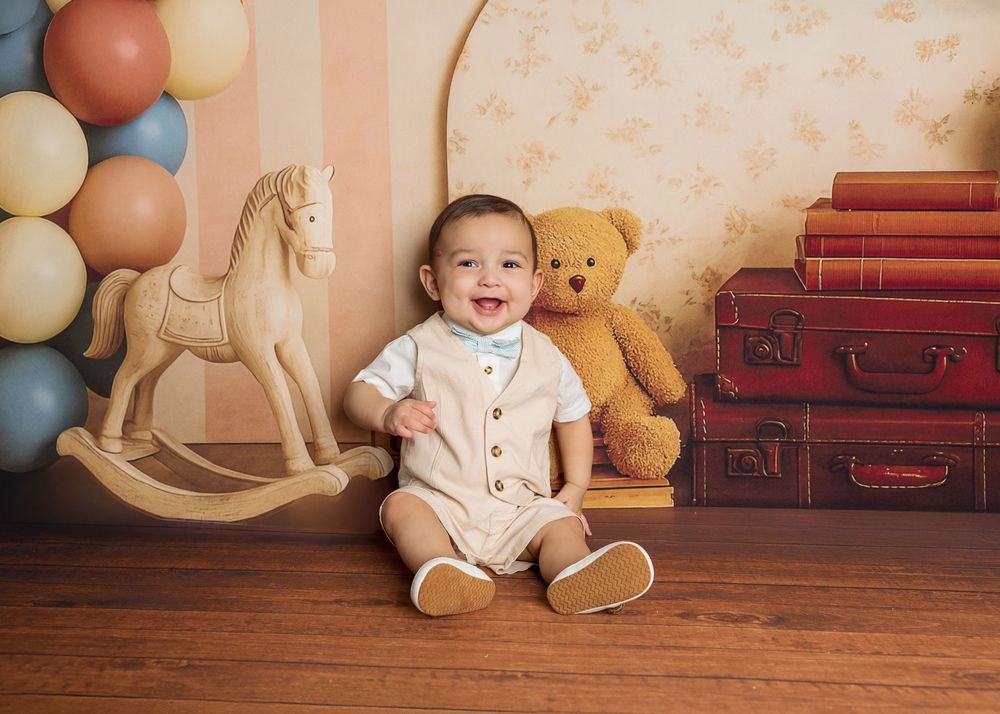 A series of vintage-styled photos showing a baby sitting on wooden floor with teddy bears and antique suitcases.