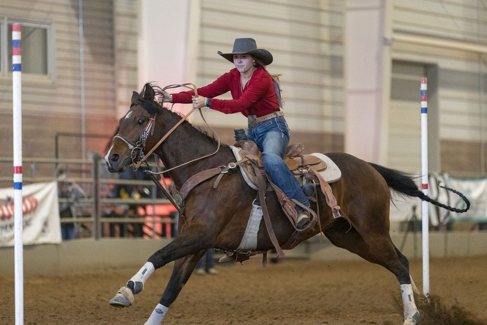 A sequence of equestrian riders performing barrel racing maneuvers in an indoor arena.