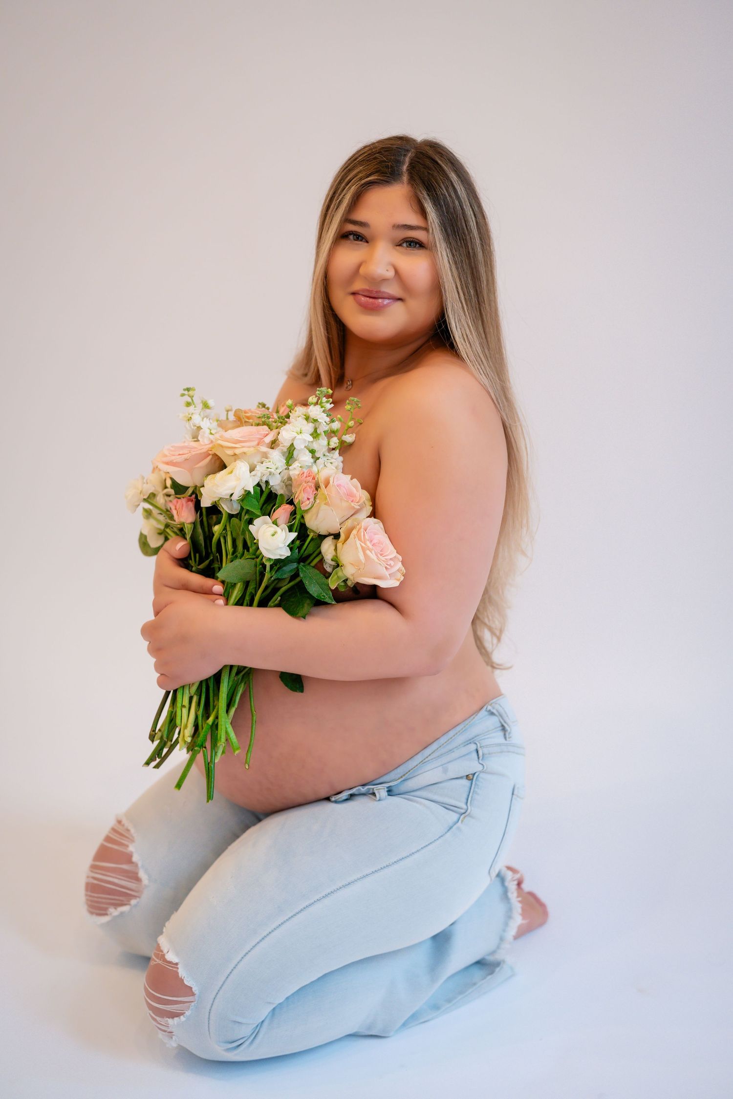 A soft and dreamy portrait session featuring light blue tones and a fresh floral bouquet.