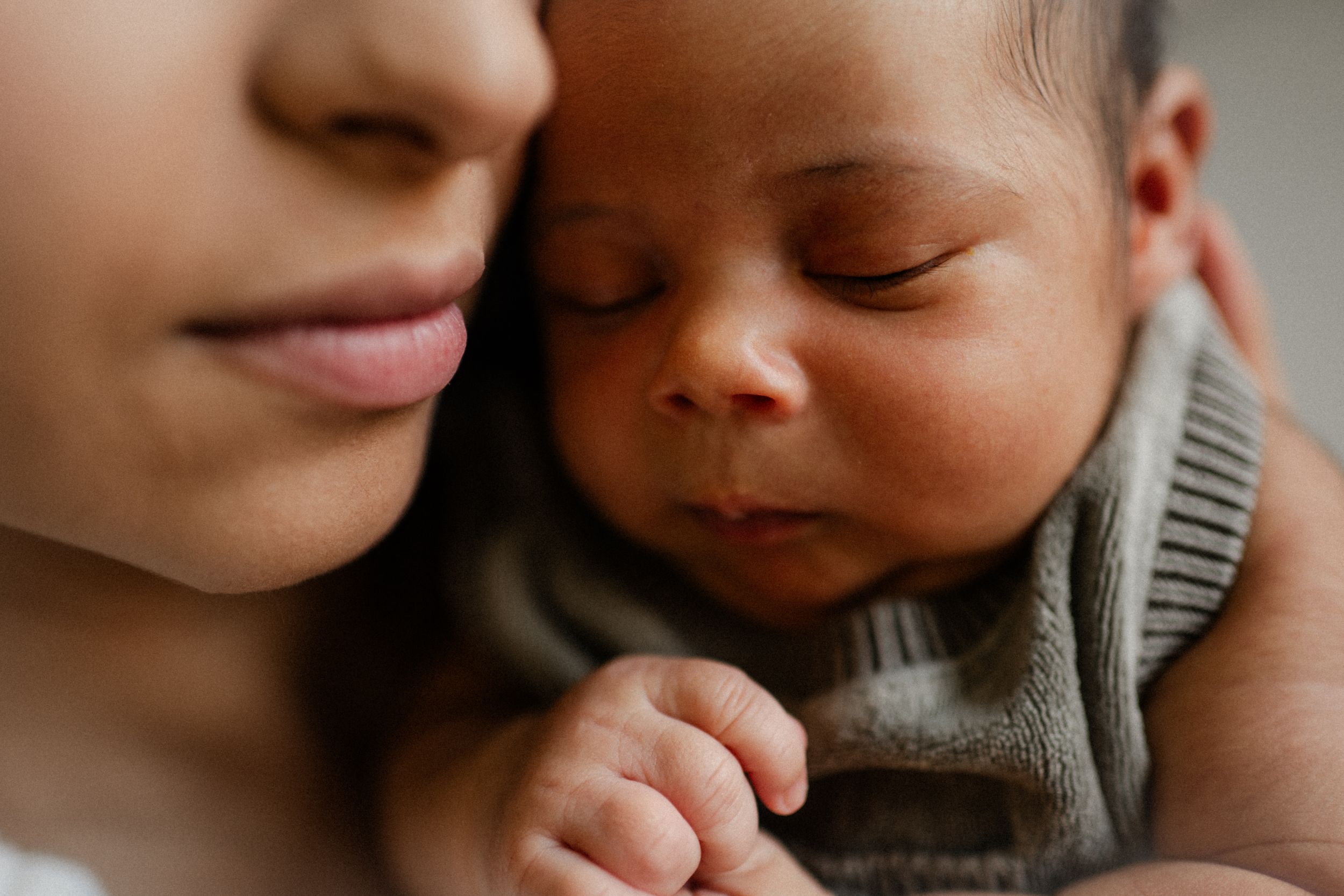 a mother holding her new born during a new born photo session with Forever Ours Photography in Kent