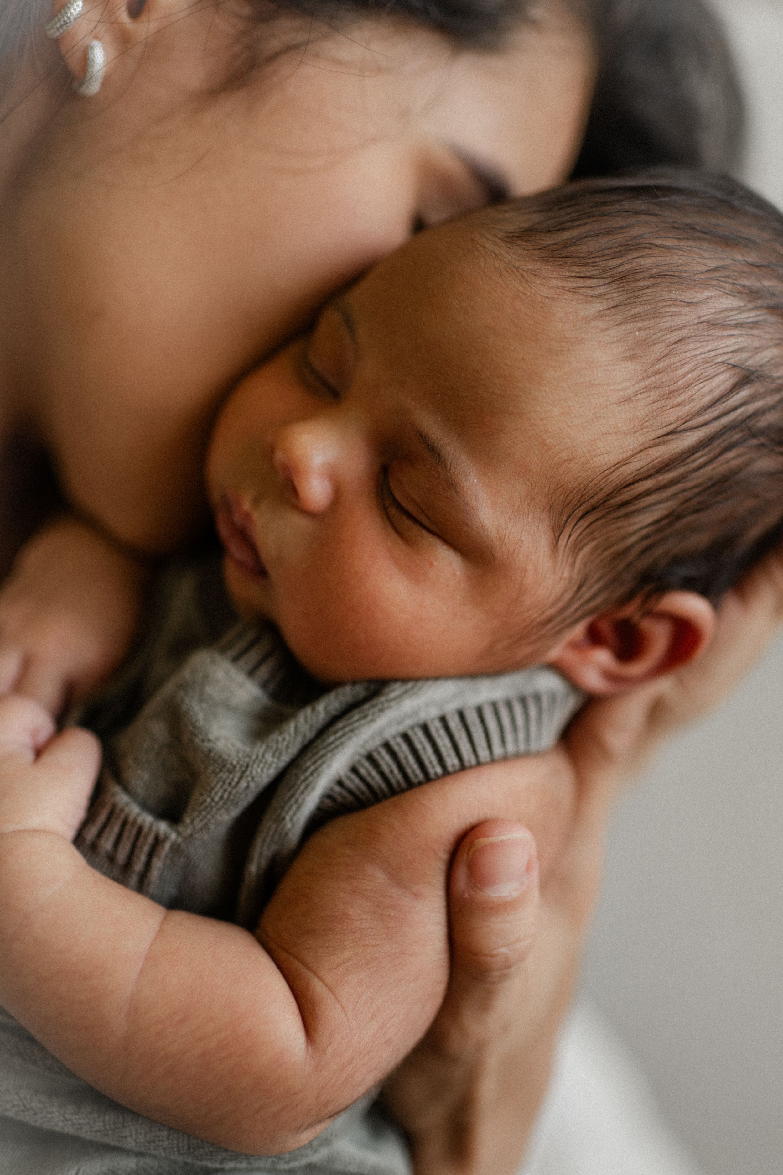 a mother holding her new born during a new born photo session with Forever Ours Photography in Kent