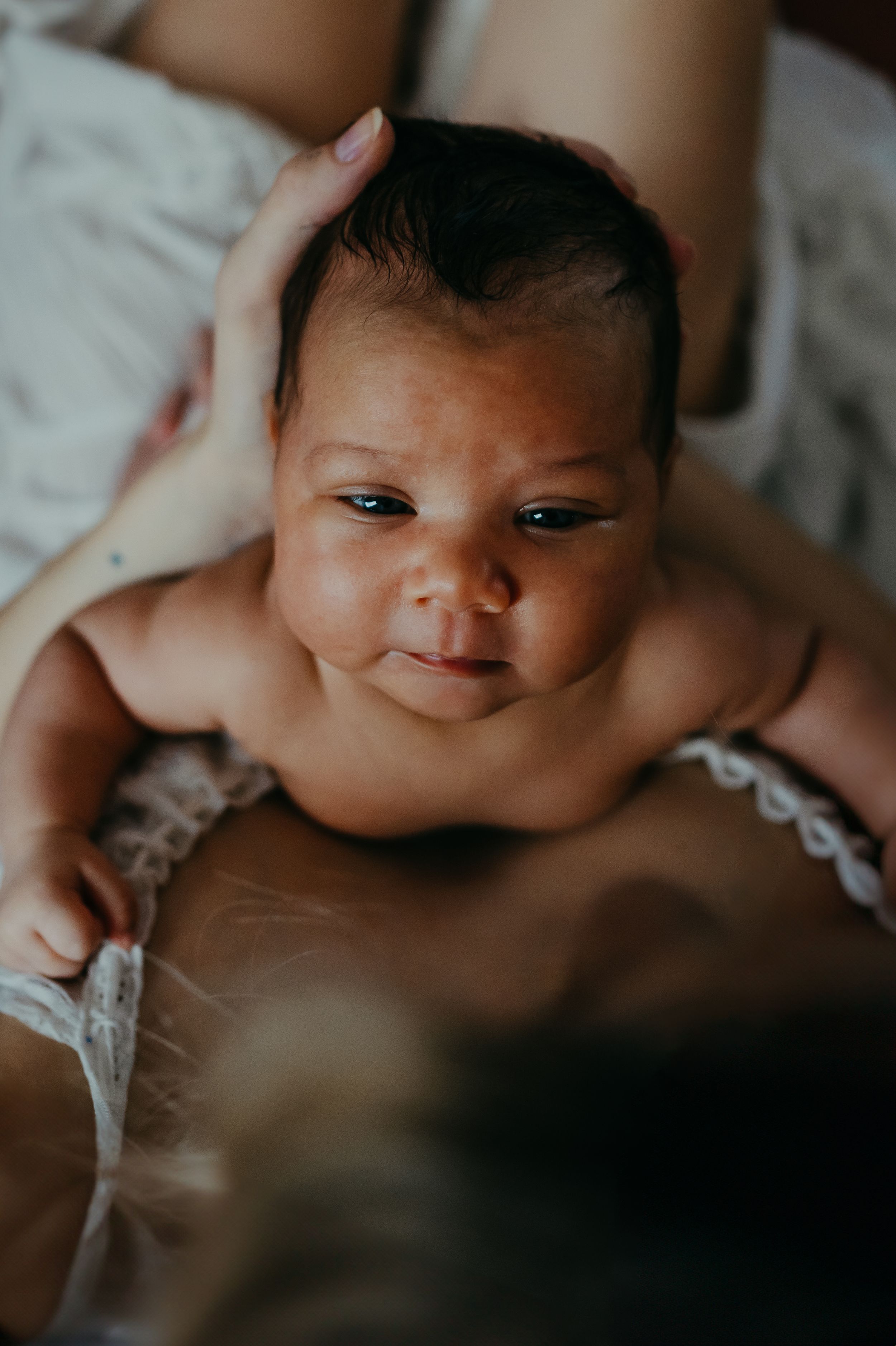 a mother holding her new born during a new born photo session with Forever Ours Photography in Kent