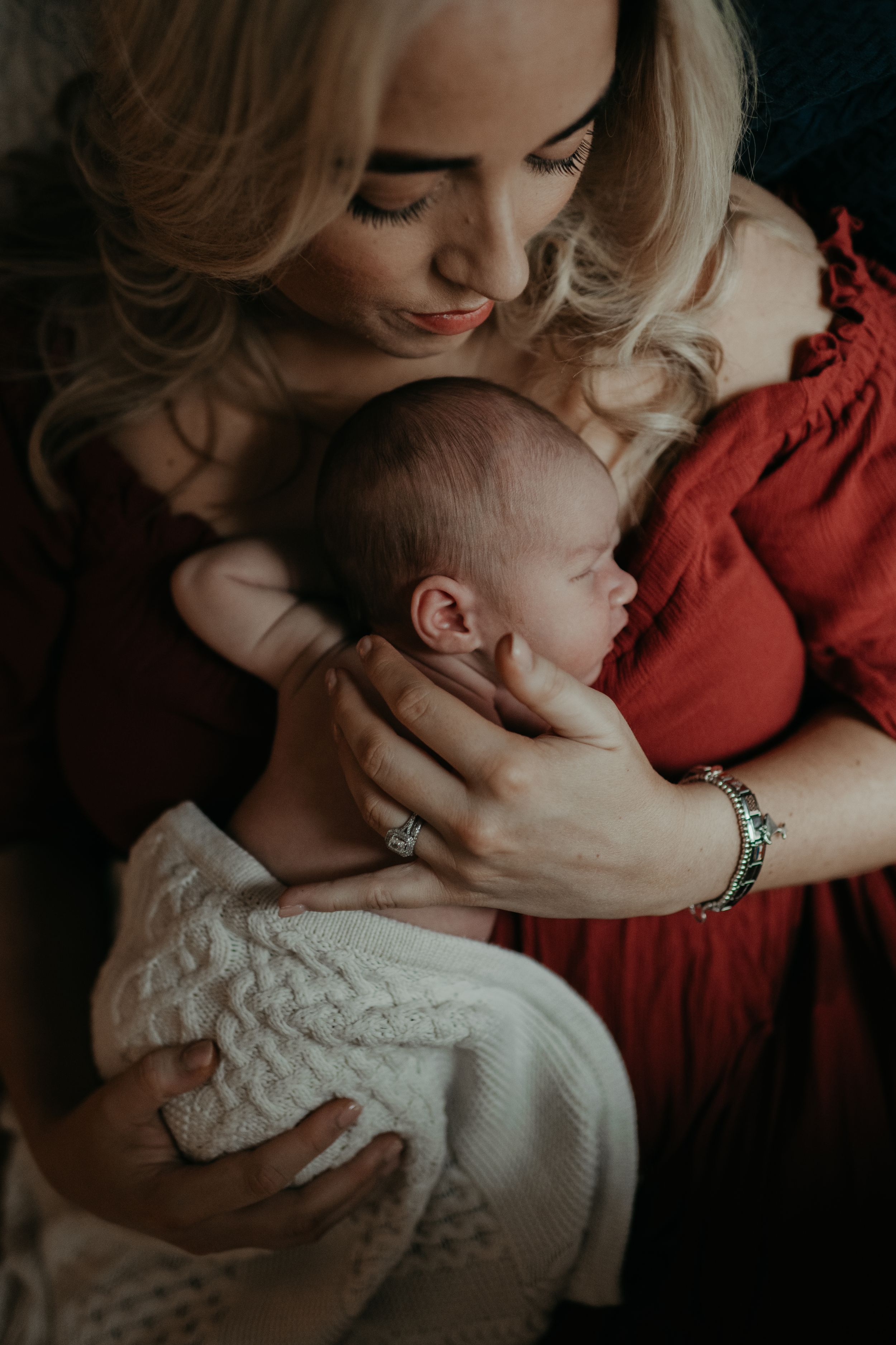 a mother holding her new born during a new born photo session with Forever Ours Photography in Kent