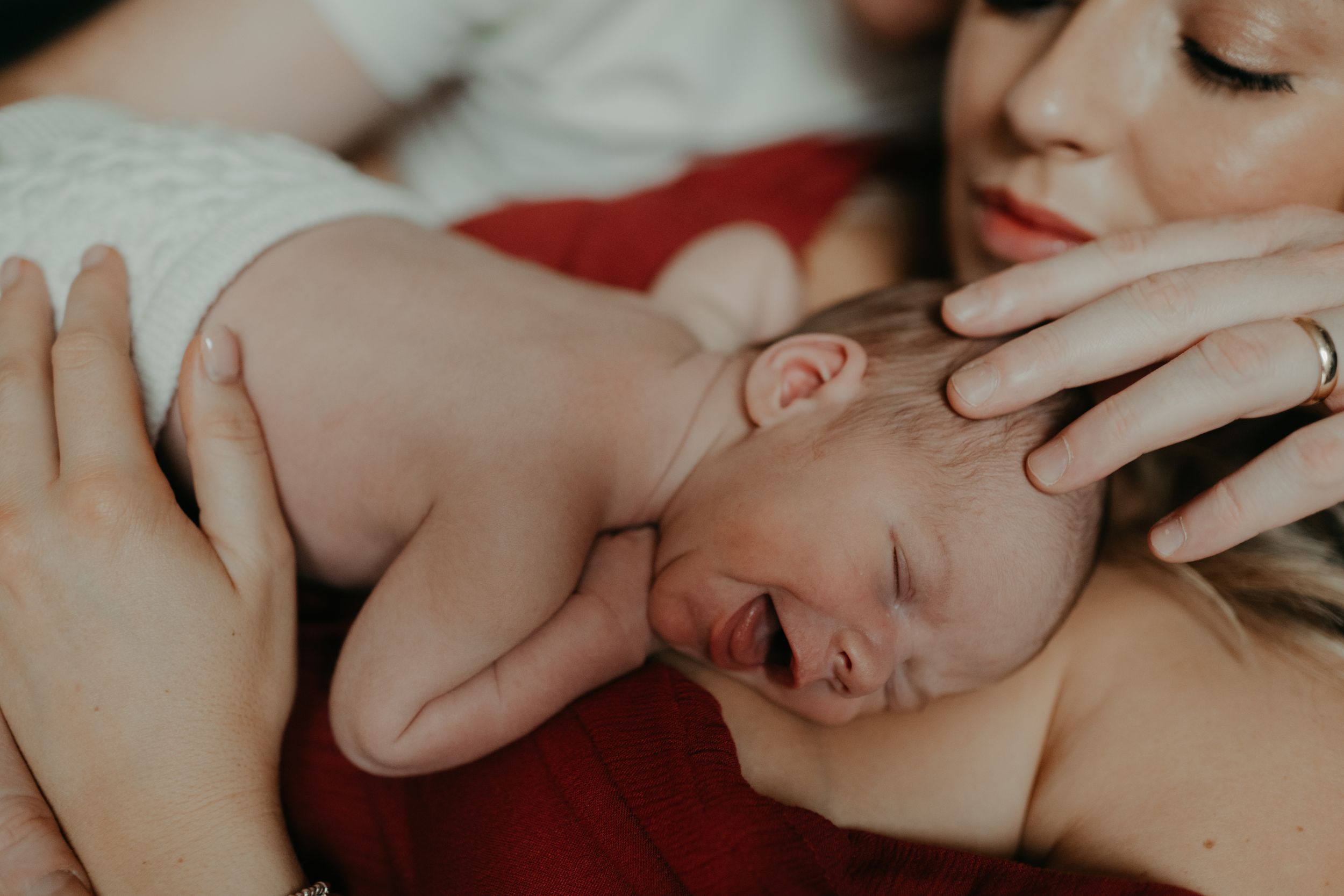 a mother holding her new born during a new born photo session with Forever Ours Photography in Kent