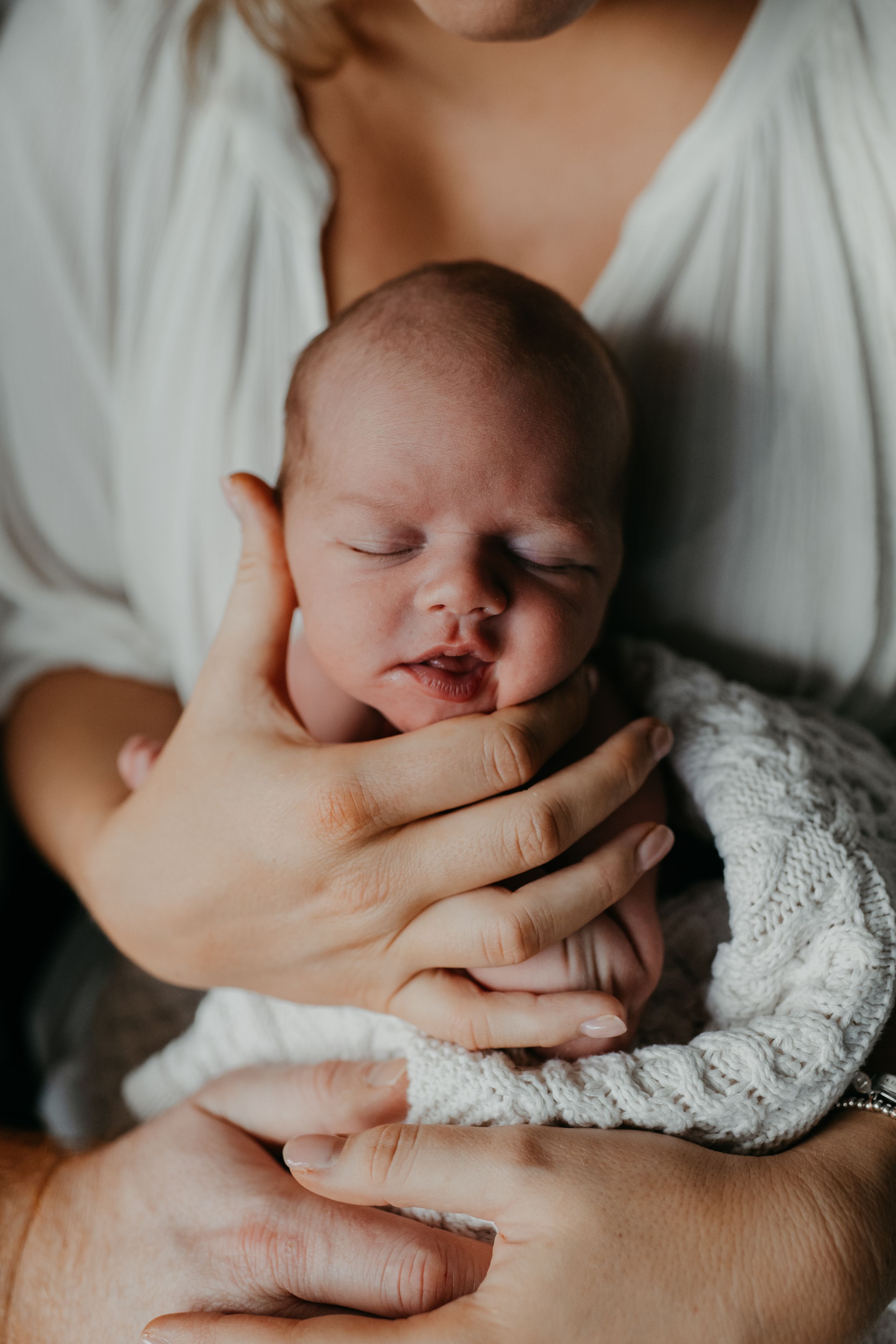 a mother holding her new born during a new born photo session with Forever Ours Photography in Kent