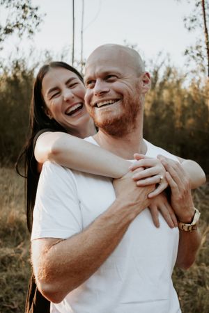 A couple hugging each other and laughing.