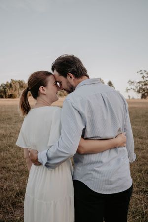 A couple resting their head on each other and hugging.