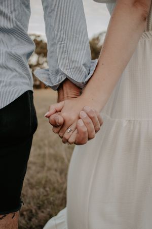 Close up of a couple holding hands.