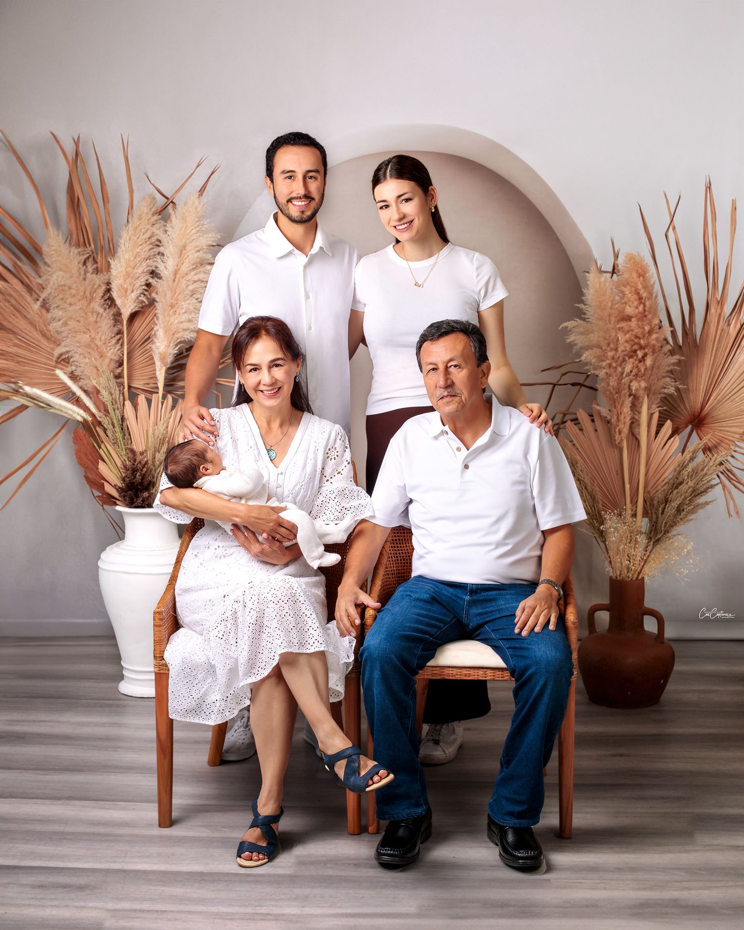 Parents and Grandparents smiling holding newborn baby boy. Family photography by Caz Captures Sydney Studio Photographer