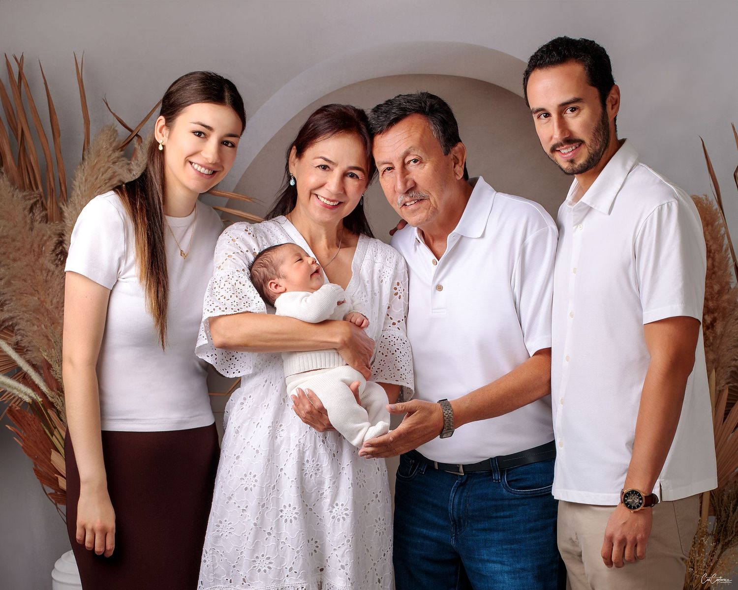 Parents and Grandparents smiling holding newborn baby boy. Family photography by Caz Captures Sydney Studio Photographer