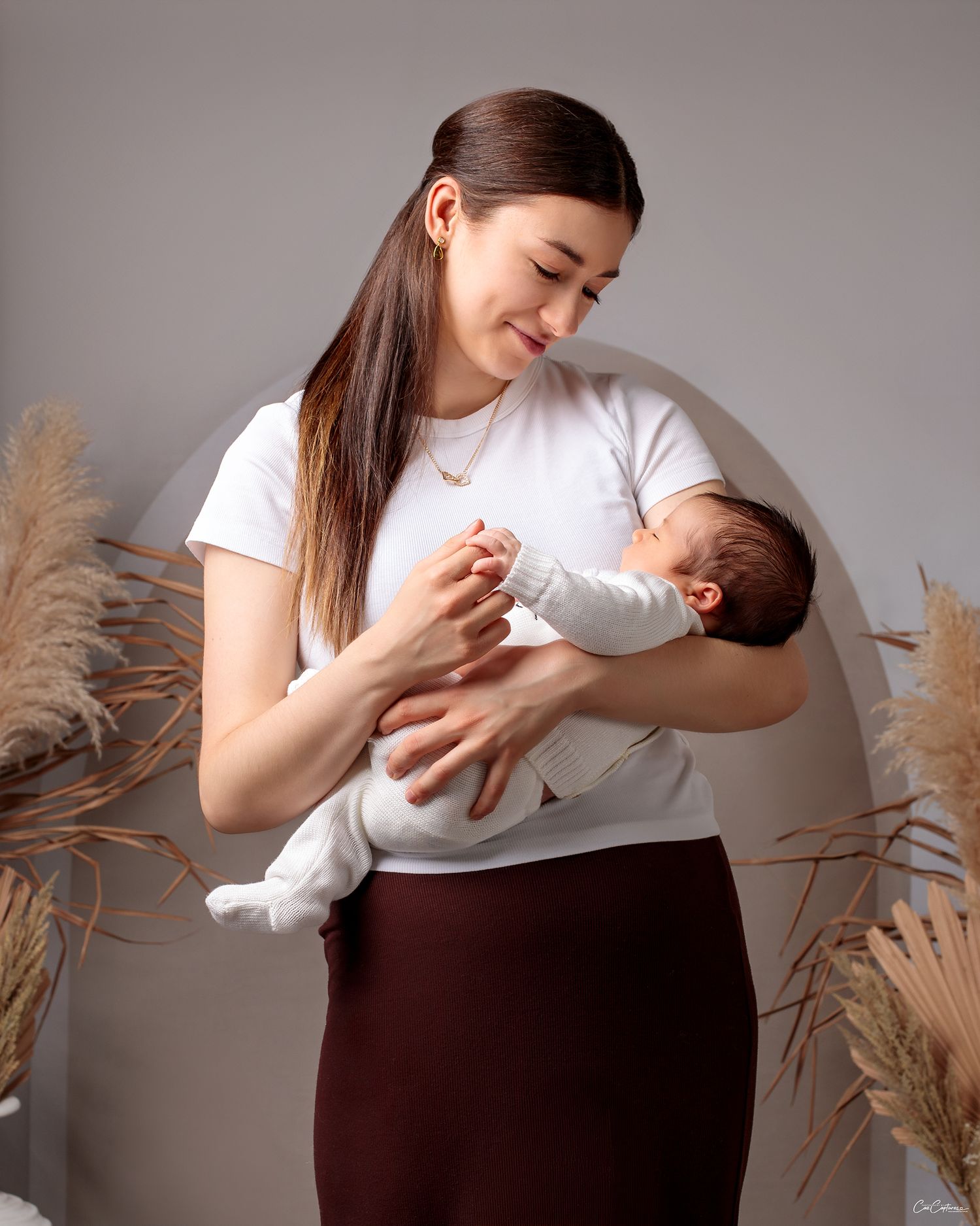 mother smiling holding newborn baby boy photography  by Caz Captures Sydney Photographer