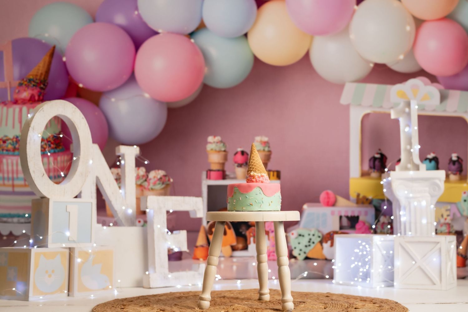 Colorful balloon garland and party decorations for a first birthday celebration.