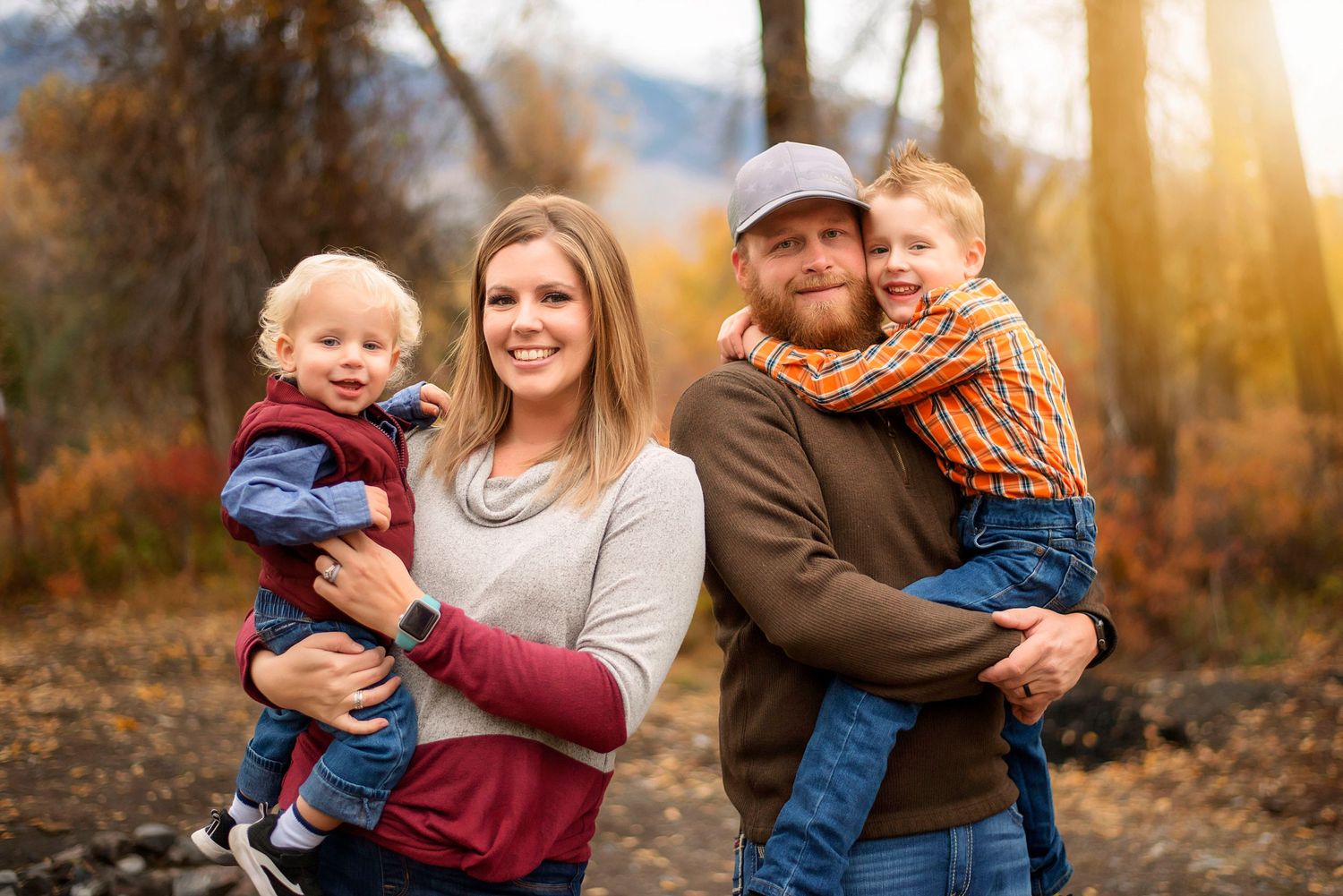 Family photography Ellensburg, Washington mom and dad hold two young boys while they smile at the camera